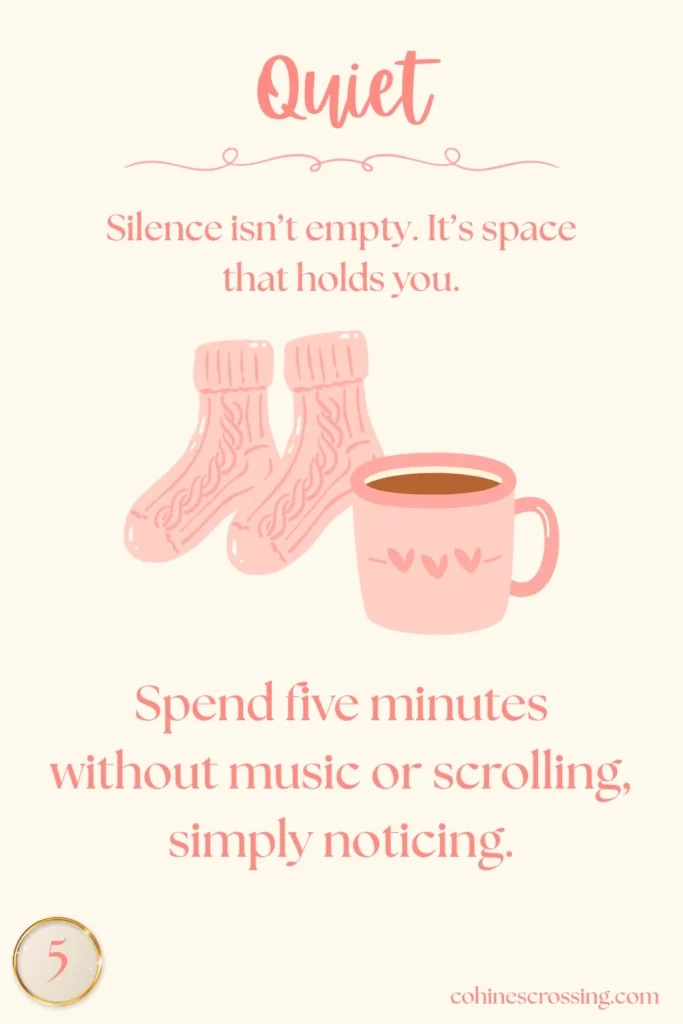 The word "quiet" written on a cream colored oracle card with a cozy pair of socks and a mug of coffee and the number 5